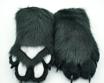May include: A pair of plush black furry paws with white paw pads and black claws. The paws are designed to look like animal paws.