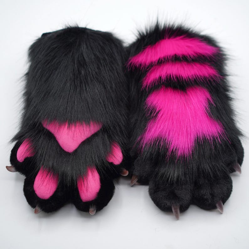 May include: A pair of black furry paws with pink accents. The paws are designed to look like cat paws and have claws.