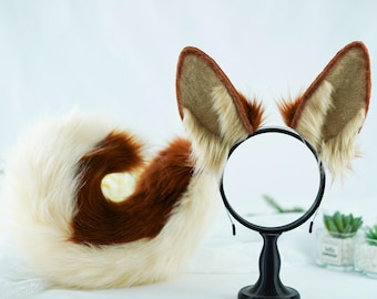 May include: A brown and white faux fur tail and a headband with brown and white faux fur ears. The headband is on a black stand with a round mirror.