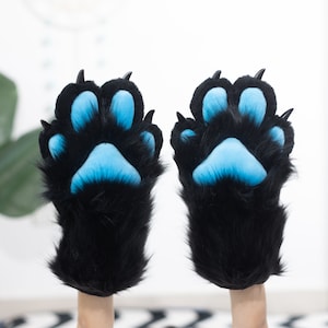 May include: A pair of black furry paw hand puppets with blue paw pads.