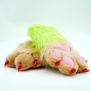 May include: A pair of plush paws with pink and brown fur and red claws. The paws are green on top.