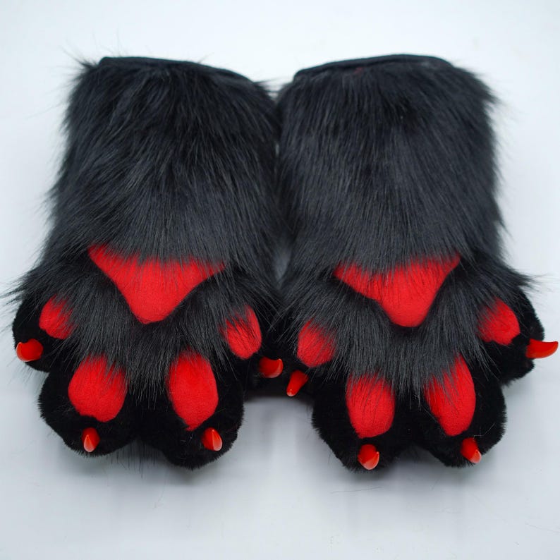 May include: A pair of black furry paw hand puppets with red paw pads and claws.