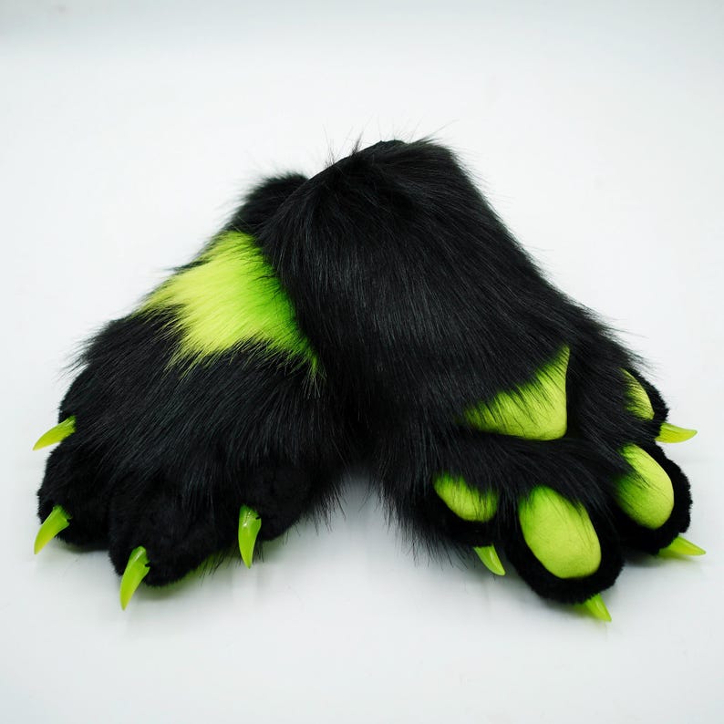 Puede incluir: Un par de patas peludas negras y verdes con garras. Las patas est&aacute;n hechas de tela suave y afelpada y tienen un aspecto realista.