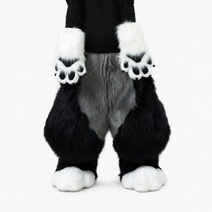 May include: A full-body faux fur costume featuring a black long-sleeved top, thick black leg coverings, and a central gray fur panel. The costume includes white paw-shaped hand covers with black paw pads and matching white paw-shaped feet.