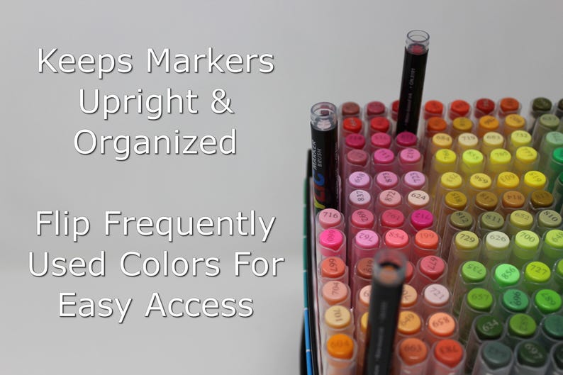 Open box of acrylic markers with some sticking up higher because of the inserts making it easier to access them while coloring. The text overlaid on the image says Keeps Markers Upright & Organized. Flip Frequently Used Colors for Easy Access.