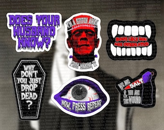 May include: A selection of Halloween-themed stickers with gothic designs and text. Features a Frankenstein image, a coffin, an eye, and phrases such as "Does Your Husband Know?" and "We Are Salt & You Are The Wound."