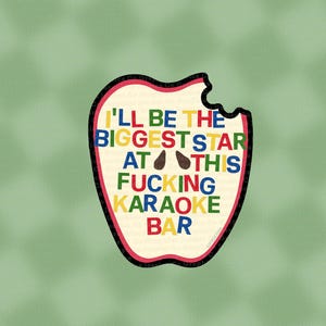 以下が含まれることがあります： 「I'LL BE THE BIGGEST STAR AT THIS FUCKING KARAOKE BAR」と書かれた、かじられたリンゴの形をしたステッカー。さまざまな色で書かれており、黒い縁取りと薄いベージュ色の内側があります。
