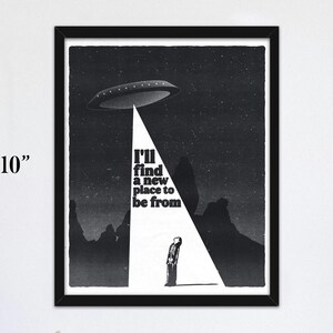 May include: Black and white print of a person standing in a beam of light from a flying saucer. The text reads "I'll find a new place to be from."
