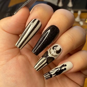 May include: Long, black and white striped, black glitter, and white nail tips with a black and white Jack Skellington design and a black and white Sally design.
