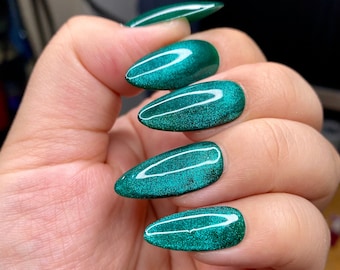 Christmas green reflective crystal cat eye gel press on nails styled in medium almond