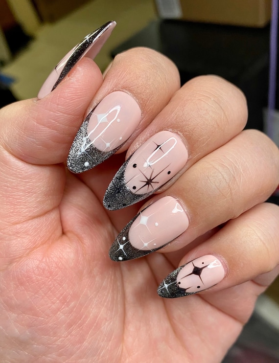 Black reflective French starry nails styled in medium almond