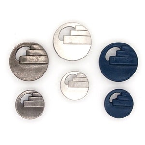 May include: Set of six round buttons with a geometric design. The buttons are in two colours: silver and dark blue.