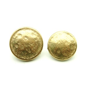 May include: A pair of gold-toned round earrings with a textured surface.