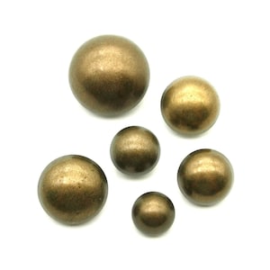 Puede incluir: Surtido de seis botones redondos de color dorado metálico. Los botones son de varios tamaños y tienen un acabado liso y brillante.