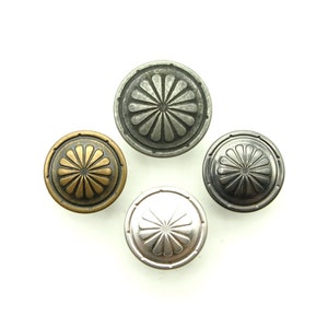 Könnte beinhalten: Vier dekorative Metallknöpfe mit Blumenmuster. Die Knöpfe sind in Silber, Gold und zwei Grautönen.