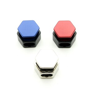 May include: Three hexagonal cable organizers in blue, red, and silver. Each organizer has a hexagonal top and a black base.