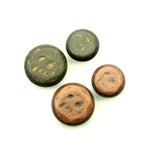 May include: Four round buttons, two are copper colored and two are dark green with gold flecks.