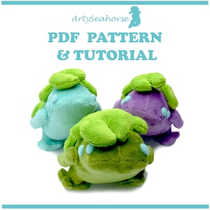 May include: Three plush toys shaped like a green, purple, and blue creature with large eyes and a leafy head. The toys are arranged in a group on a white background. The text "PDF PATTERN & TUTORIAL" is displayed above the toys.