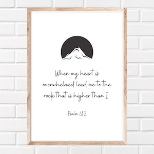 May include: Black and white printable wall art featuring a mountain silhouette and the text "When my heart is overwhelmed lead me to the rock that is higher than I Psalm 61:2"