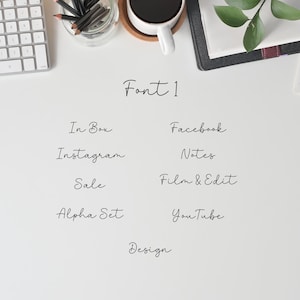 Op de afbeelding: Een wit oppervlak met de woorden "Font 1" geschreven in zwarte cursieve letters. Onder de titel staan ​​verschillende woorden in hetzelfde lettertype, waaronder "In Box", "Instagram", "Sale", "Alpha Set", "Facebook", "Notes", "Film & Edit", "YouTube" en "Design".