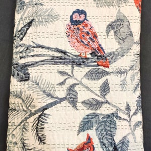 May include: White cotton quilt with a gray and blue floral pattern and two red and pink owls. The quilt is quilted with a small stitch pattern.