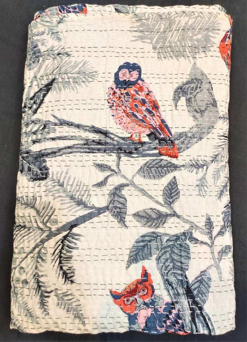 May include: White cotton quilt with a gray and blue floral pattern and two red and pink owls. The quilt is quilted with a small stitch pattern.
