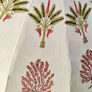 May include: White fabric with a repeating pattern of pink and green floral designs. The fabric features a variety of flowers and leaves.