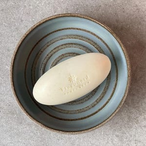 Op de afbeelding: Een rustiek houten bord met de tekst "Welcome to our porch" in witte letters. Het bord heeft een verweerde afwerking en een eenvoudig, uitnodigend ontwerp, perfect voor buitendecoratie.