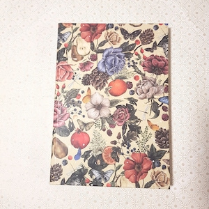 May include: A vintage-style wrapping paper with a floral pattern featuring red, pink, and blue flowers, butterflies, pears, and citrus fruits on a cream background.