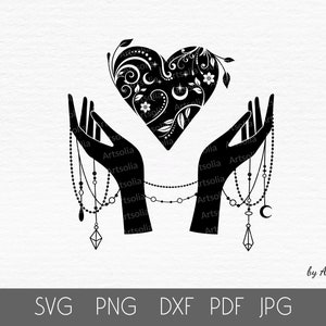 May include: Black and white graphic of two hands holding a heart. The heart is decorated with floral and celestial designs. The hands are adorned with beaded jewelry. The image includes the text "SVG PNG DXF PDF JPG" and "by Artsolia".