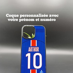 Peut inclure: Coque de téléphone bleue personnalisée avec un design de maillot de foot. Le nom "ARTHUR" et le numéro "10" sont en blanc. Le texte "Coque personnalisée avec votre prénom et numéro" est en haut.