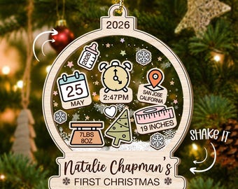 Puede incluir: Un adorno navideño de madera en forma de globo con el texto 2026, Natalie Chapman's FIRST CHRISTMAS, e iconos que incluyen un biberón, un calendario marcado 25 MAY, un reloj a las 2:47PM, un pin de ubicación SAN JOSE CALIFORNIA, 7LBS 8OZ y 19 INCHES.