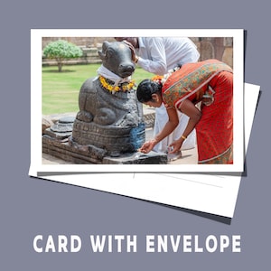 May include: A photograph of a card with an envelope. The image on the card depicts a stone statue of a bull adorned with garlands. Two people are shown performing a ritual. The text "CARD WITH ENVELOPE" is at the bottom.