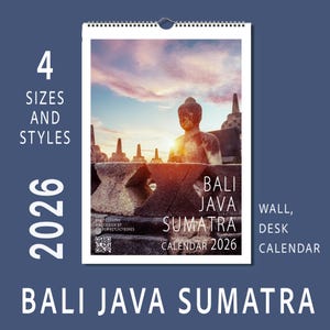 May include: A 2026 wall and desk calendar featuring a photograph of a Buddha statue and temple in Bali, Java, and Sumatra. The calendar has a spiral binding and includes the text "BALI JAVA SUMATRA CALENDAR 2026". The background is a blue gradient.