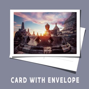 Könnte beinhalten: Eine Postkarte mit einer Stein-Buddha-Statue und Tempelstrukturen bei Sonnenuntergang. Die Karte ist weiß mit einem weißen Umschlag. Der Text "CARD WITH ENVELOPE" befindet sich am unteren Rand des Bildes.