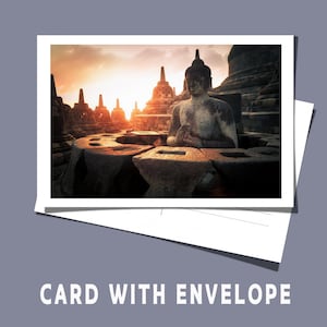 Op de afbeelding: Een foto van een stenen Boeddha-standbeeld en tempelcomplex bij zonsondergang, afgedrukt op een witte kaart met een envelop. De tekst "CARD WITH ENVELOPE" staat onderaan de kaart.