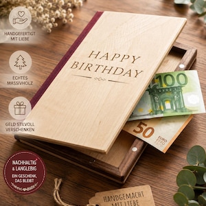 Könnte beinhalten: Eine rechteckige Geschenkbox aus Holz mit einem hellen Holzdeckel, der mit dem Text HAPPY BIRTHDAY graviert ist. Die Box hat einen dunklen Holzrahmen und einen weinroten Buchrücken. Ein 100-Euro- und ein 50-Euro-Schein stecken darin. Ein braunes Etikett trägt die Aufschrift HANDGEMACHT MIT LIEBE.