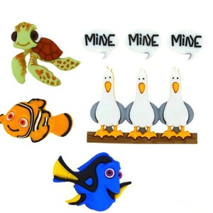 May include: A set of decorative flat-backed embellishments featuring a green sea turtle, an orange and white clownfish, a blue tang fish, and three white seagulls perched on a brown branch with three white speech bubbles each containing the text MINE.