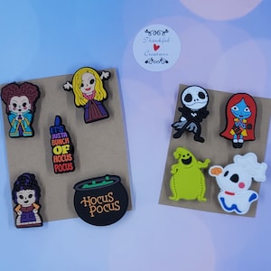 May include: A collection of nine colorful rubber shoe charms featuring characters and symbols from Hocus Pocus and The Nightmare Before Christmas, including figures of witches, a black cauldron, a skeleton, a ghost dog, and a green monster.