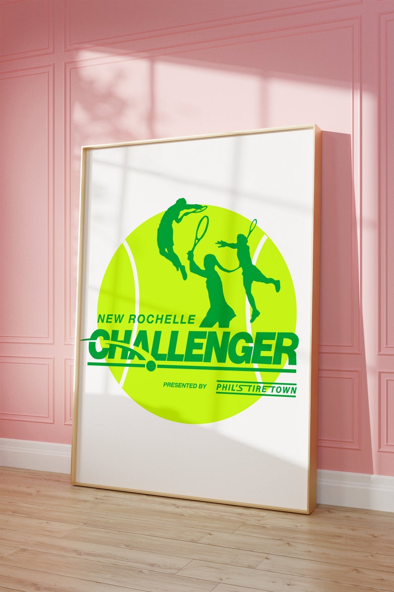 K&ouml;nnte beinhalten: Ein gr&uuml;ner Tennisball mit zwei Silhouetten von Tennisspielern in Aktion. Der Text "NEW ROCHELLE CHALLENGER" ist in Gr&uuml;n unter dem Ball geschrieben. Der Text "PRESENTED BY PHIL'S TIRE TOWN" ist in Schwarz unter dem Text "CHALLENGER" geschrieben.