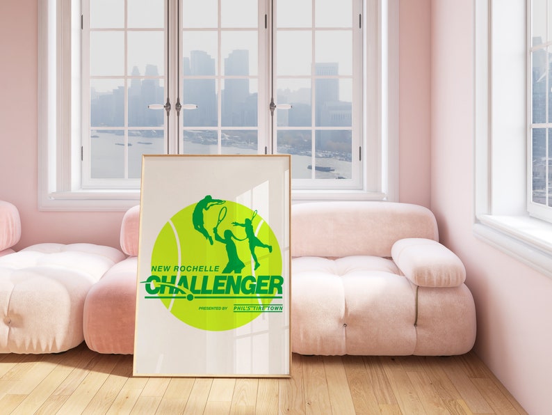 K&ouml;nnte beinhalten: Ein gerahmtes Poster mit einer gr&uuml;nen Tennisballgrafik und zwei Tennis spielenden Silhouetten. Der Text "New Rochelle Challenger" ist in gr&uuml;nen Buchstaben geschrieben, darunter die Worte "Presented by Phil's Tire Town".