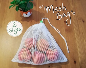 Può includere: Una borsa di rete bianca per prodotti con chiusura a cordoncino verde. La borsa è piena di mele rosse. Il testo "Mesh Bag" è scritto con un pennarello nero su una superficie di legno. Il testo "2 sizes" è scritto in verde su un cerchio bianco.