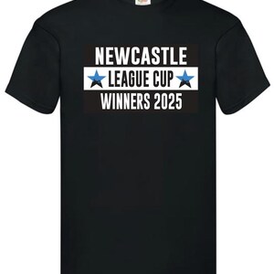 May include: Black t-shirt with the text "NEWCASTLE LEAGUE CUP WINNERS 2025" in white, with a blue star on each side of "LEAGUE CUP". The text is on a black and white rectangular background.