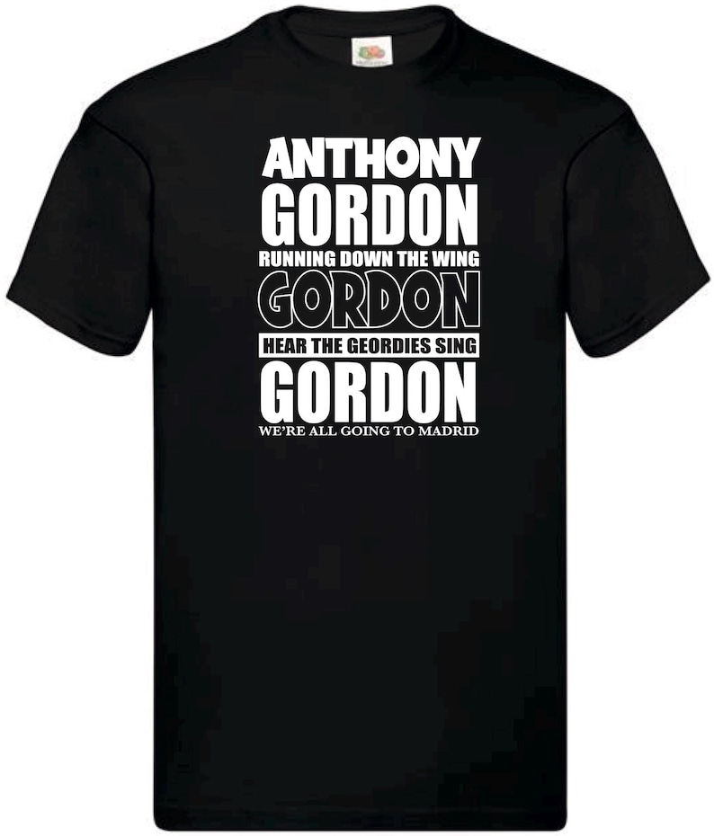 Może przedstawiać: Czarna koszulka z białym tekstem. Tekst brzmi "ANTHONY GORDON" na g&oacute;rze, a następnie "RUNNING DOWN THE WING", "GORDON", "HEAR THE GEORDIES SING", "GORDON" i "WE'RE ALL GOING TO MADRID" na dole.