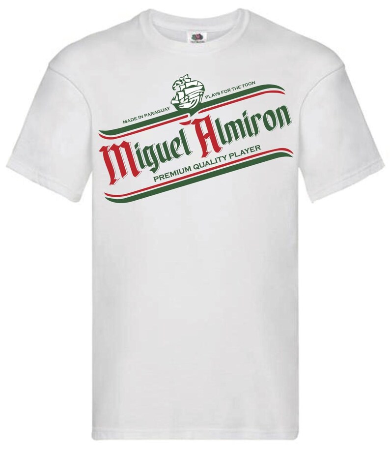 May include: White t-shirt with a green and red graphic of a beer label that says "Miguel Almiron" with the text "Made in Paraguay" and "Plays for the Toon" above the name and "Premium Quality Player" below the name.