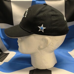 May include: Black baseball cap with a white brim and a blue star on the front. The cap has the text "The Lads" embroidered on the side.