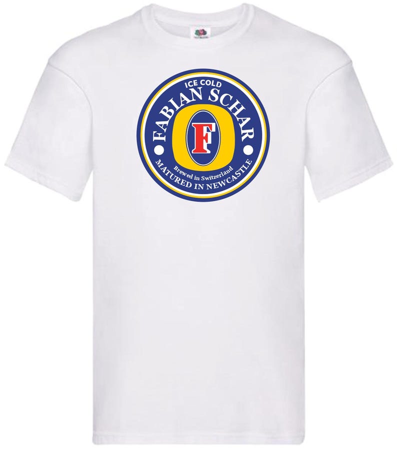 May include: White t-shirt with a blue and yellow logo that says "Ice Cold Fabian Schar Brewed in Switzerland Matured in Newcastle".