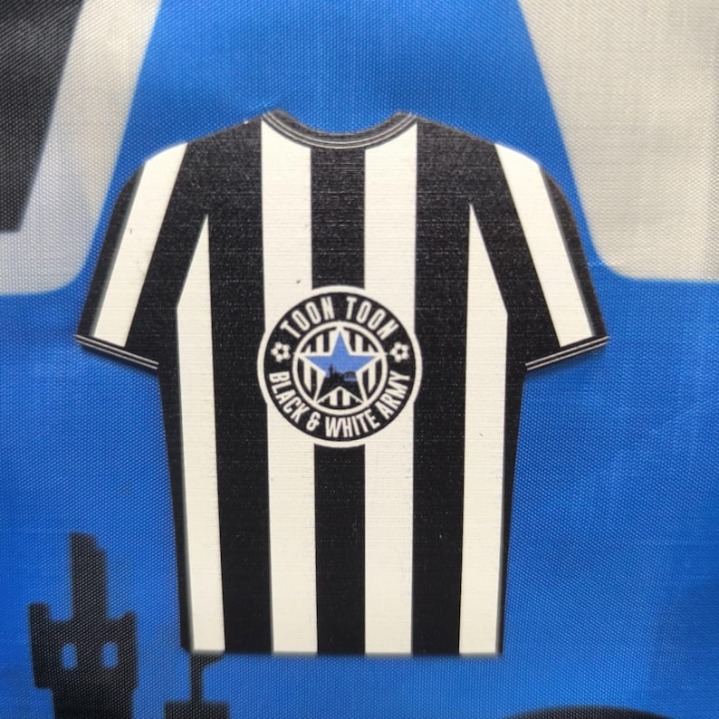 May include: Black and white striped soccer jersey with a circular patch that says "Toon Toon Black & White Army" with a blue star in the center.