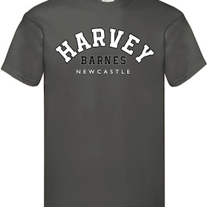 May include: A dark gray t-shirt with a white arched graphic that says "Harvey Barnes Newcastle".