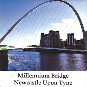 May include: A white arch bridge over a river with buildings in the background. The bridge is called the Millennium Bridge and is located in Newcastle Upon Tyne.